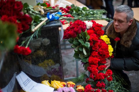 A man places flowers outside the building of the Alexandrov Ensemble in Moscow on Sunday. Alexander Kibovsky, head of Moscow's culture department, called them "our cultural paratroopers."
