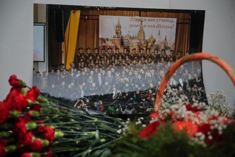Flowers lay in front of a photo of the Alexandrov Ensemble at the group's building in Moscow. "These people always performed in war zones, they wore uniforms, they brought kindness and light," Kibovsky said.