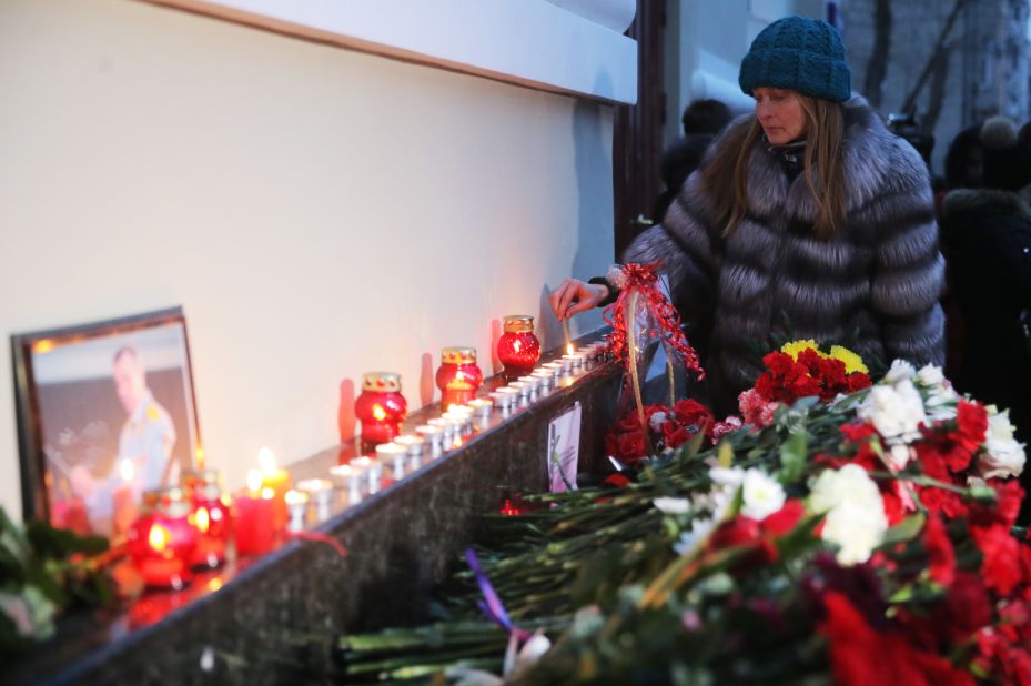 A woman lights a candle at a memorial in Moscow.