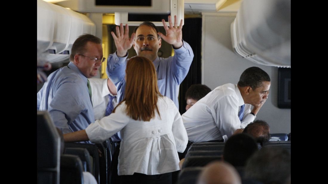 Obama talks on the phone aboard his plane as members of the campaign travel to St. Paul, Minnesota, in June 2008.