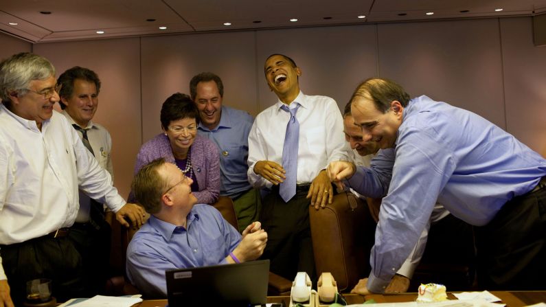 Obama laughs with aides aboard Air Force One in November 2009.