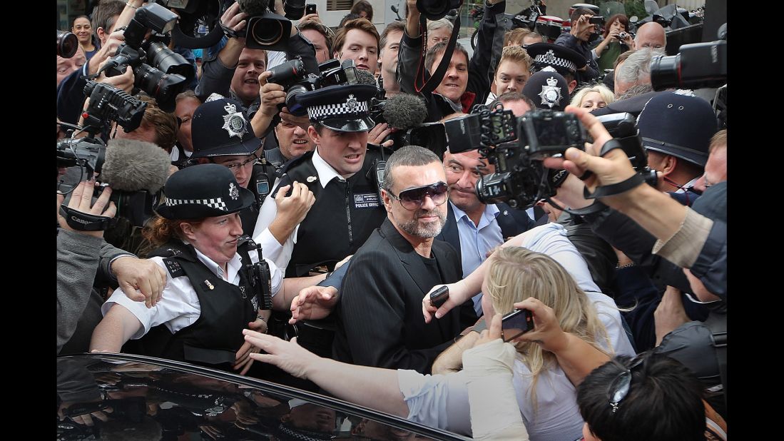 Singer George Michael, center, is surrounded by press and police on August 24, 2010 in London, after leaving a courthouse. Michael pleaded guilty to driving under the influence of drugs and possessing cannabis after he crashed his car into a photo processing shop in London the month before.