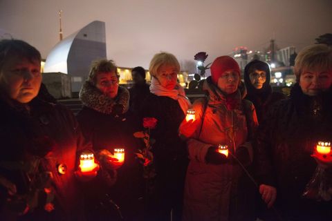People hold a candlelight vigil for victims of the crash on Sunday, December 25, in Sochi.