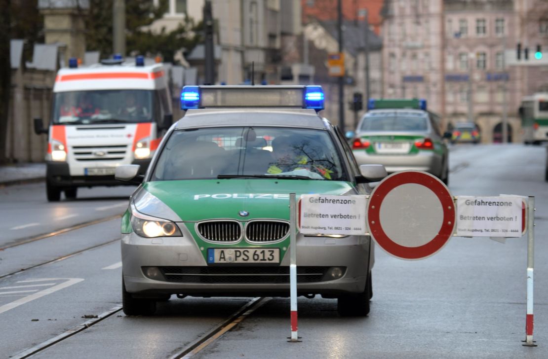 Police cars and an ambulance are seen beside a road block on an empty street in Augsburg, southern Germany, during a mass evacuation on Christmas Day.