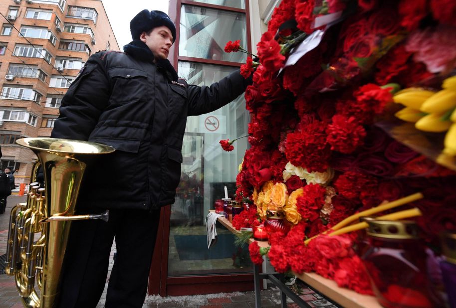 A Russian police orchestra musician places a flower in tribute to members of the Alexandrov Ensemble outside their home stage building in Moscow on December 26. The popular ensemble was scheduled to perform for Russian pilots in Syria ahead of New Year's Day.
