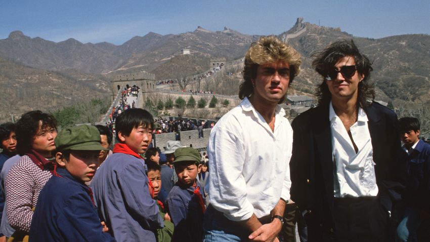 CHINA - 1985/04/07: Young children sporting "Mao" jackets and caps gape at George Michael (left) and Andrew Ridgeley, of the pop group Wham who are visiting the Great Wall as they promote the first-ever gig by a Western pop band in communist China.

Wham played a concert at Beijing's People's Stadium, thereby becoming a milestone not only in pop but also in Chinese history, even if most Chinese hadn't a clue who they were and even fewer actually got to see them in action.. (Photo by Peter Charlesworth/LightRocket via Getty Images)