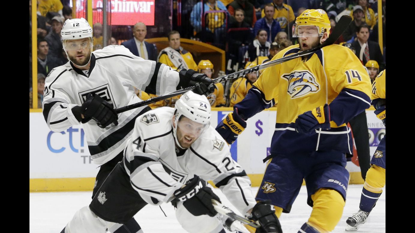 Nashville's Mattias Ekholm, right, takes a stick to the face from Los Angeles' Marian Gaborik during an NHL game in Nashville on Thursday. Los Angeles won 4-0.