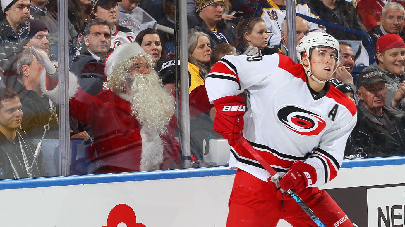 An ice hockey fan dressed as Santa Claus reacts as Carolina's Victor Rask controls the puck against Buffalo during an NHL game in Buffalo, New York, on Thursday. Carolina won 3-1.