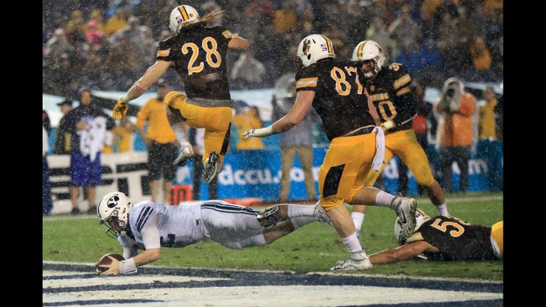 Brigham Young's Tanner Mangum dives for a touchdown against Wyoming during a Poinsettia Bowl college football game in San Diego on Wednesday. Wyoming lost 21-24.