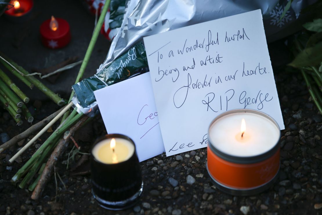 Messages and candles are seen among floral tributes outside the singer's home.