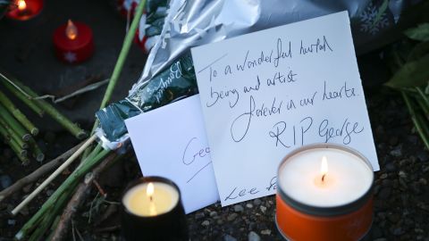 Messages and candles are seen among floral tributes outside the singer's home.