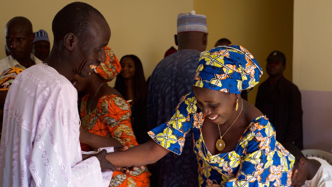 A father greets his daughter after she arrived with 20 other freed Chibok girls.<br />