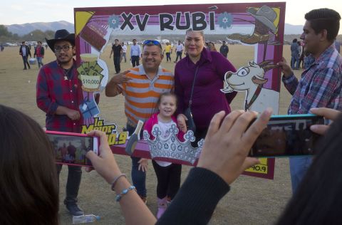 Guests have their picture taken behind a frame at Rubi's birthday party. 