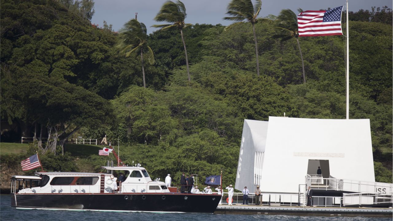  A boat carrying Obama and Abe arrives at the USS Arizona Memorial.
