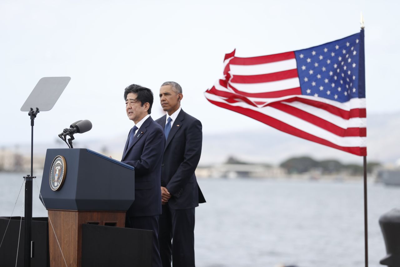 President Barack Obama listens as Japanese Prime Minister Shinzo Abe speaks on Kilo Pier overlooking the USS Arizona Memorial in Joint Base Pearl Harbor-Hickam, Hawaii, on Tuesday, December 27. His remarks were part of a ceremony to honor those killed in the Japanese attack on the naval harbor. Abe is the first Japanese prime minister to visit Pearl Harbor with a US president and the first to visit the USS Arizona Memorial.