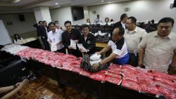 Philippine Justice Secretary Vitaliano Aguirre II, center, and National Bureau of Investigation Director Dante Gierran, 3rd from right, display nearly one metric ton of seized methamphetamine during a press conference in Manila, Philippines Tuesday, Dec. 27, 2016. Aguirre II said Tuesday the 890 kilograms (1,962 pounds) of methamphetamine seized in the series of raids that started on Dec. 1 until Dec. 26 has a street value of nearly 6 billion pesos ($120 million), the biggest drug haul in the country so far. 10 people including 3 Chinese nationals were arrested during the raids. (AP Photo/Aaron Favila)