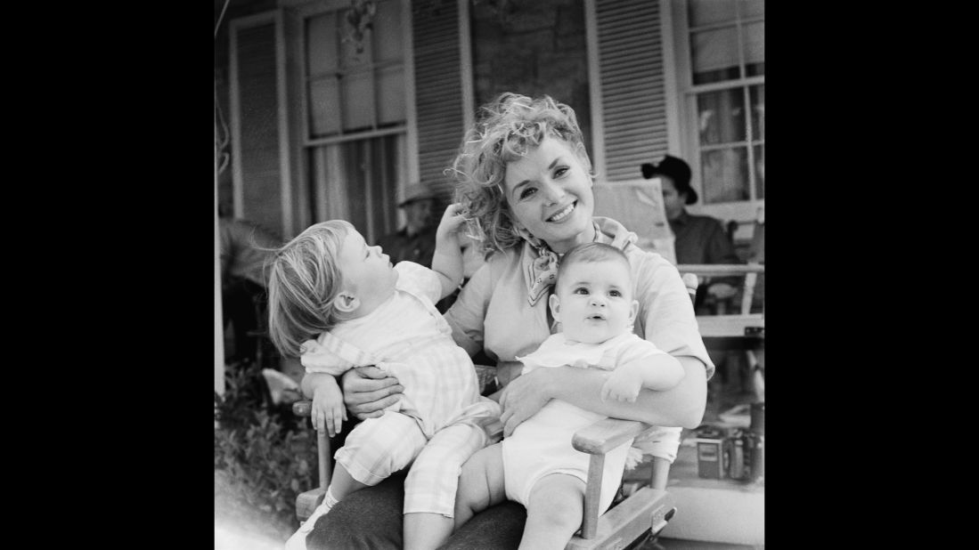 Reynolds holds her two children, Carrie and Todd, right, during the shooting of 1959's "The Mating Game."