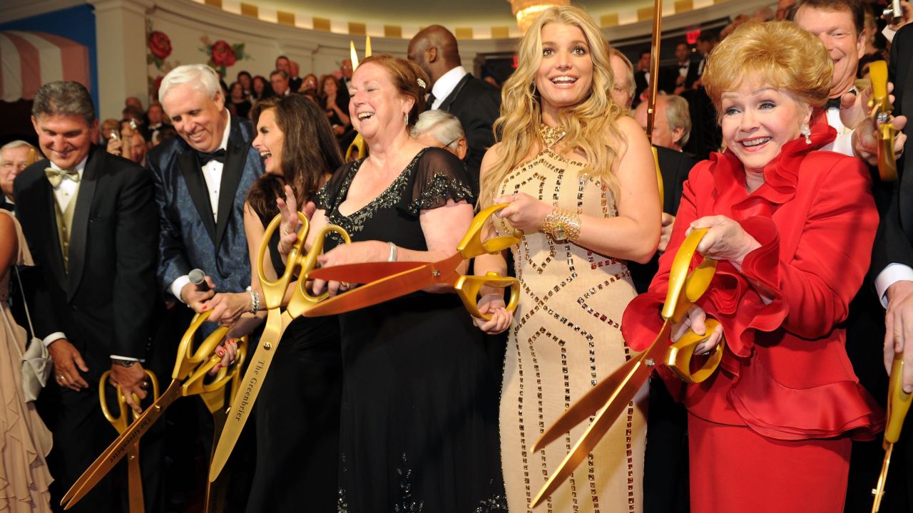 Reynolds takes part in the ribbon cutting at the opening of of the Casino Club at The Greenbrier on July 2, 2010, in White Sulphur Springs, West Virginia, with West Virginia Gov. Joe Manchin; Greenbrier owner and chairman Jim Justice; Brooke Shields; Kathy Justice; and singer Jessica Simpson.