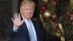US President-elect Donald Trump waves to the media after meeting with David Rubenstein, co-founder of Carlyle Group December 28, 2016 at Mar-a-Lago in Palm Beach, Florida.