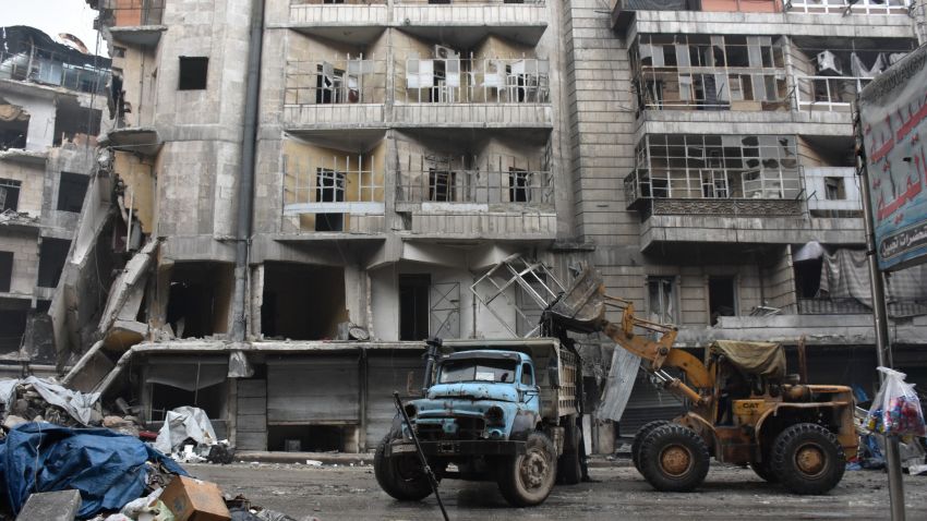 A tractor removes rubble as the Syrian government starts to clean up areas formerly held by opposition forces in the northern city of Aleppo on December 27, 2016, in the Shaar district.