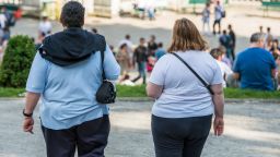 An obese couple walk in a park near Montmartre, in Paris, France. 