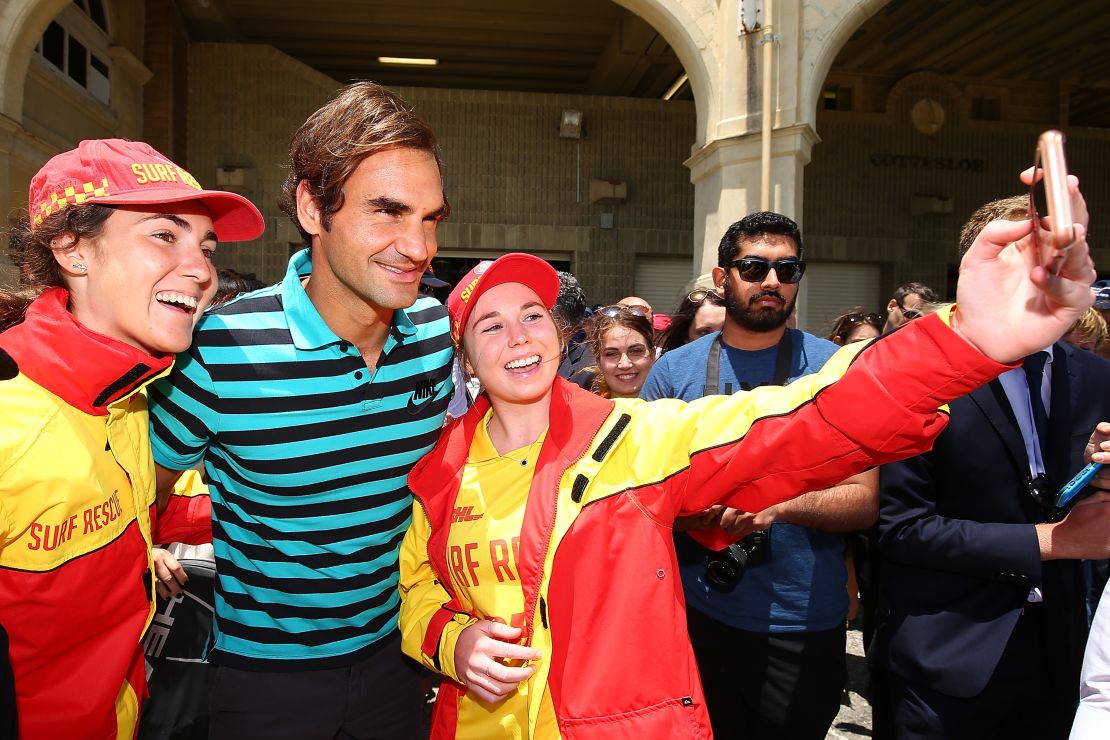 Federer poses for selfies with surf lifesavers at Cottesloe Beach.