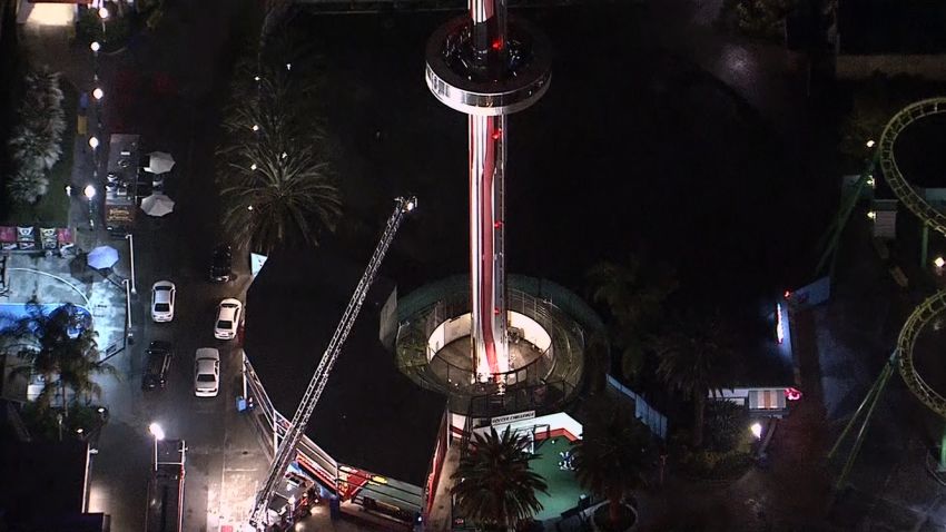 Fire truck ladder tries unsuccessfully to reach people trapped on Sky Cabin ride. Fire officials had to use ropes to safely lower 21 people to the ground. 