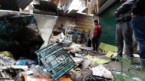 Iraqis look at the aftermath following a double blast in a busy market area in Baghdad's central al Sinag street on December 31, 2016.