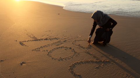 A Palestinian girl writes "2017" on the sand during the last sunset of 2016 on a beach in Gaza City on New Year's Eve.