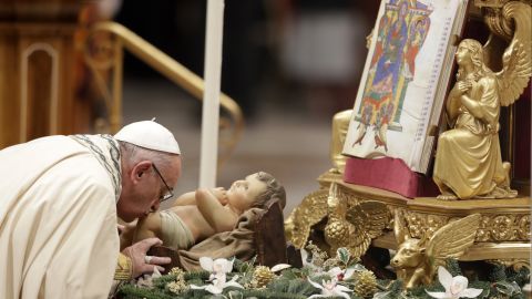 Pope Francis kisses a statue of an infant Jesus during a New Year's Eve vespers mass in St. Peter's Basilica at the Vatican.
