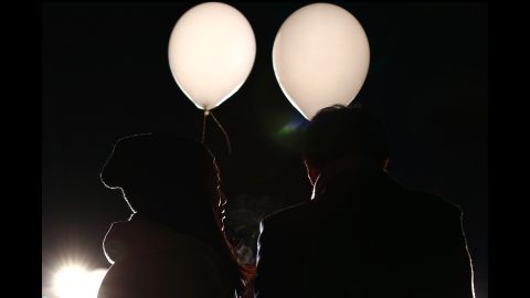 A couple holds balloons containing their wishes for the new year during celebrations at Prince Park Tower in Tokyo, Japan.