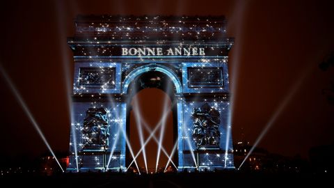 The Arc de Triomphe in Paris, France, is illuminated by a laser and 3D mapping display reading "Bonne Année" ("Happy New Year").