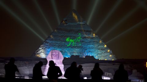 People watch a light show by the Giza Pyramids and Sphinx in Egypt.