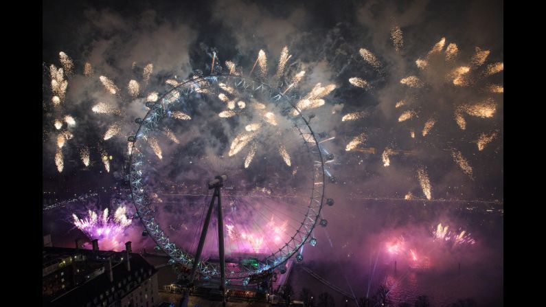 Fireworks are lit near the London Eye just after midnight in London, England.