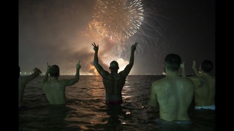People watch fireworks explode over Copacabana Beach during celebrations in Rio de Janeiro, Brazil.
