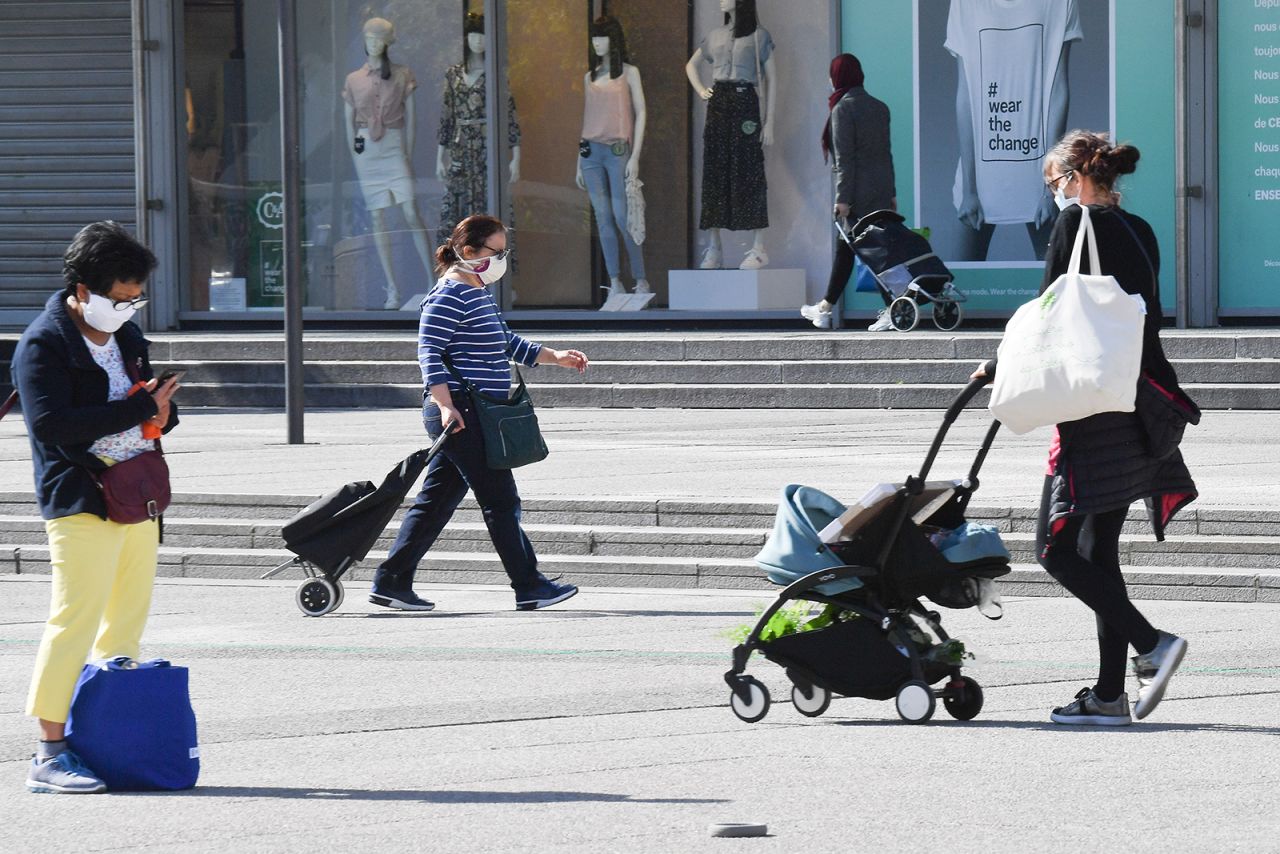 People wearing face masks walk in the La Defense business district of Paris on Thursday, May 7, in Paris.