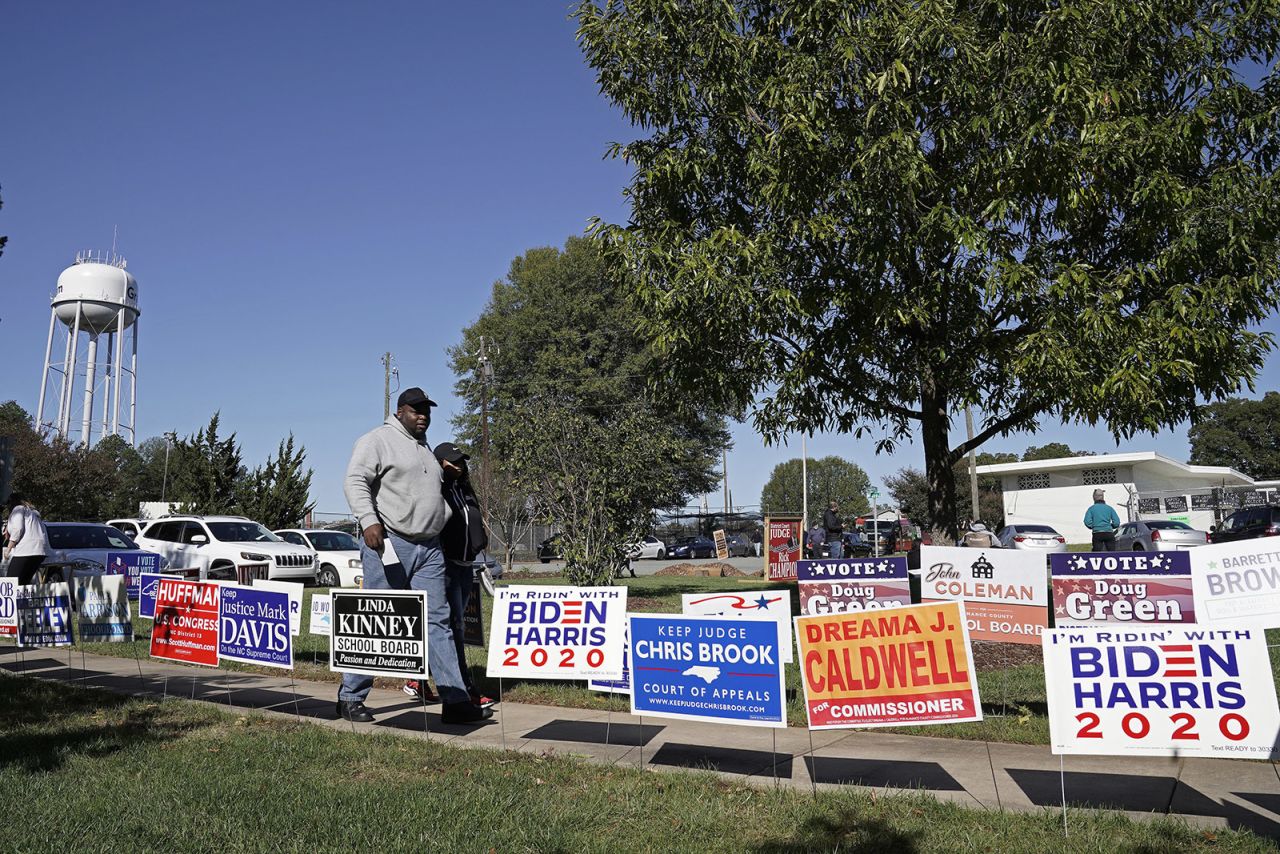 Voters walk past campaign signs at the Graham Civic Center polling location in Graham, North Carolina, on Tuesday. 