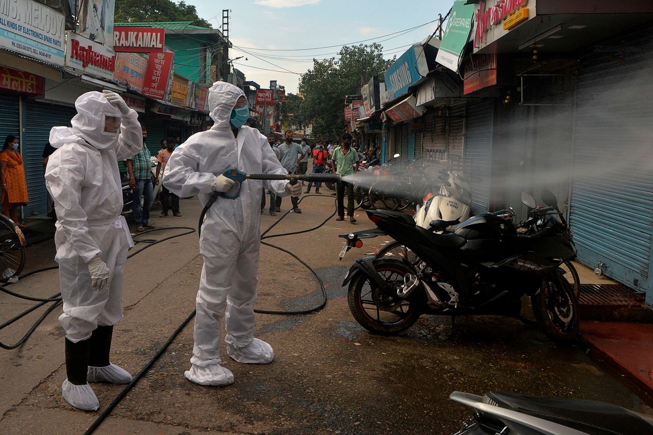 Firefighters wearing personal protective gear spray disinfectant in a closed market in Siliguri, India on June 22.