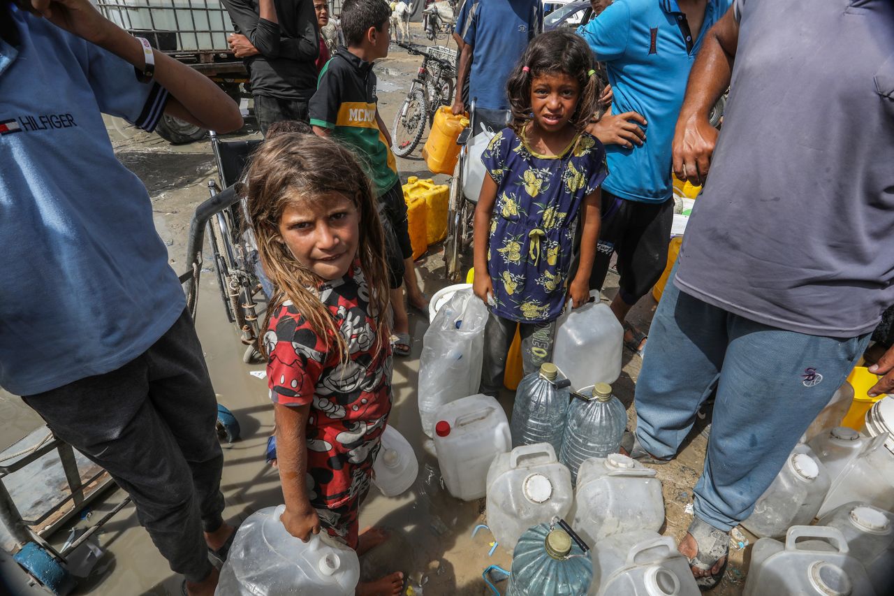 Palestinians form queues to receive clean water distributed by aid organizations in Gaza on May 20.