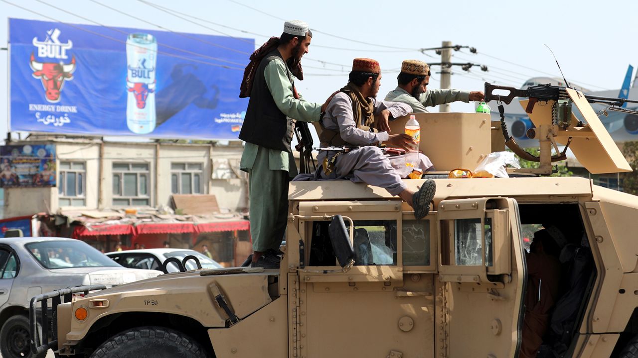 Taliban fighters stand guard in front of the Hamid Karzai International Airport, in Kabul, Afghanistan, on August 16. 