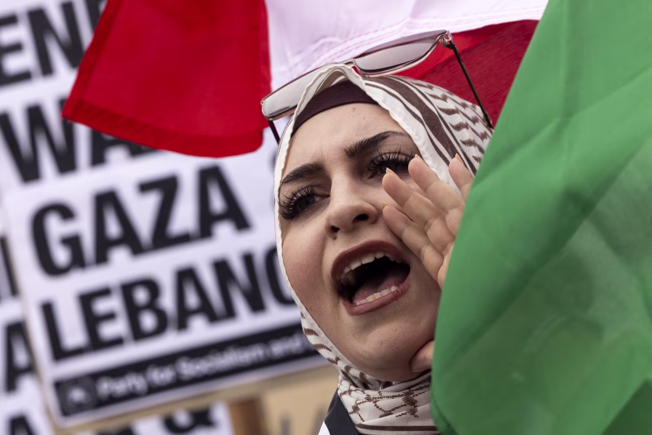 A protester waves a Lebanese flag as demonstrators gather to protest against the war on Gaza and Israeli military strikes on Lebanon in front of the Los Angeles Federal Building on Tuesday.