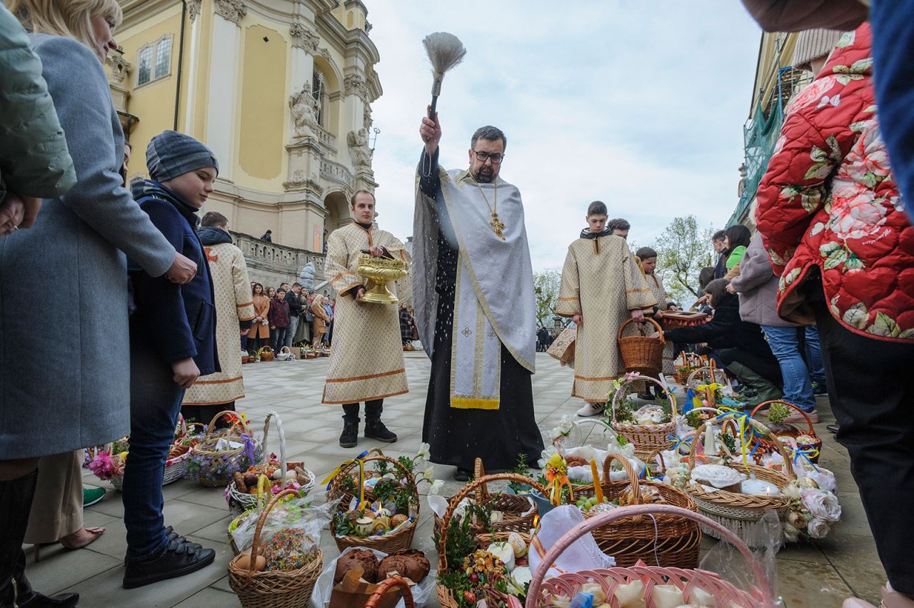 A Ukrainian priest blesses traditional cakes and painted eggs prepared for an Easter celebration in the in Lviv, Ukraine, Saturday, April 23.