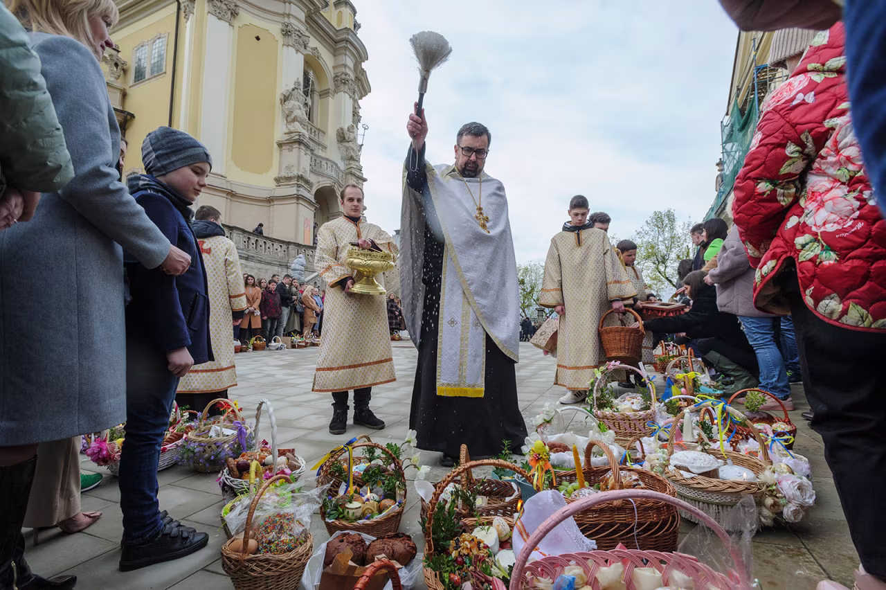 A Ukrainian priest blesses traditional cakes and painted eggs prepared for an Easter celebration in the in Lviv, Ukraine, Saturday, April 23.