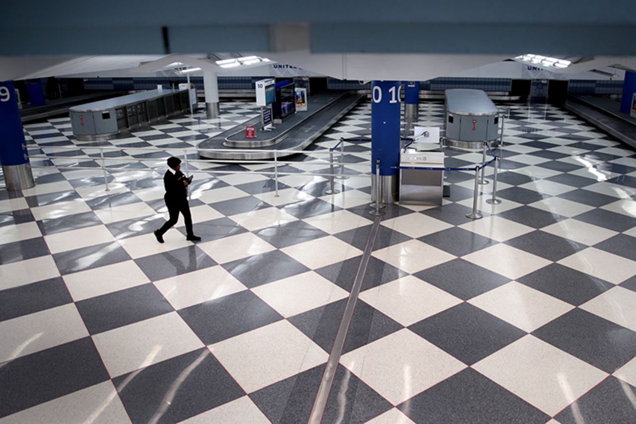 A worker walks through a baggage claim area at a nearly-empty O'Hare International Airport on April 2,  in Chicago.