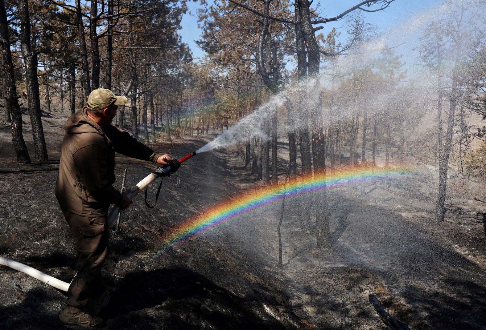 A firefighter extinguishes the remains of a forest fire near the settlement of Ordzhonikidze, Crimea, on Monday, September 15.