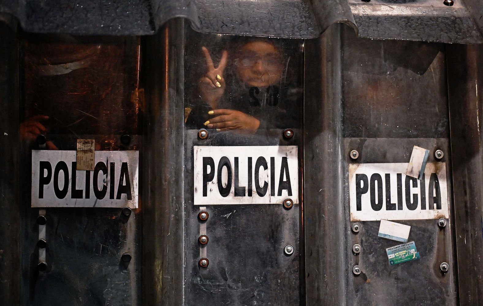 A riot police officer gestures as she takes cover from molotov cocktails during a protest on the 11th anniversary of the disappearance of 43 students from the southern town of Ayotzinapa in Mexico City on Friday, September 26. In September 2014, students from the Ayotzinapa Rural Normal School disappeared after being forcibly abducted in what has been called one of Mexico's most infamous human rights cases.