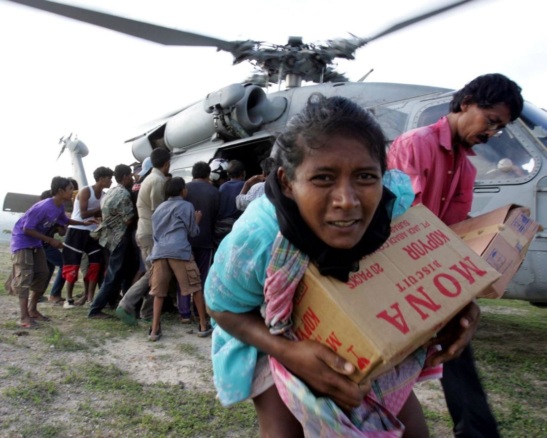 Los refugiados del tsunami reciben suministros en Krueng Raya, Indonesia.