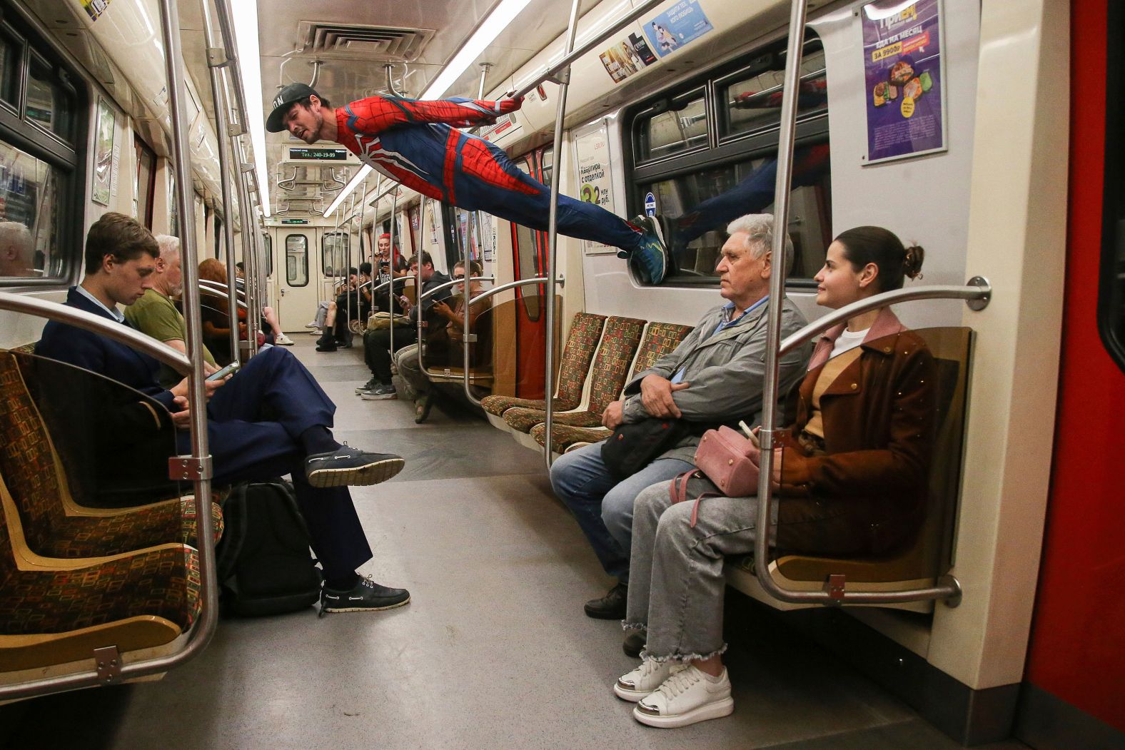 An acrobat dressed as Spider-Man performs in a subway train in St. Petersburg, Russia, on Tuesday, June 11.