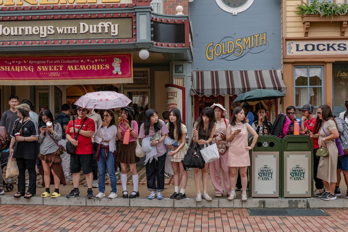 A crowd gathers to watch a parade on Main Street USA.