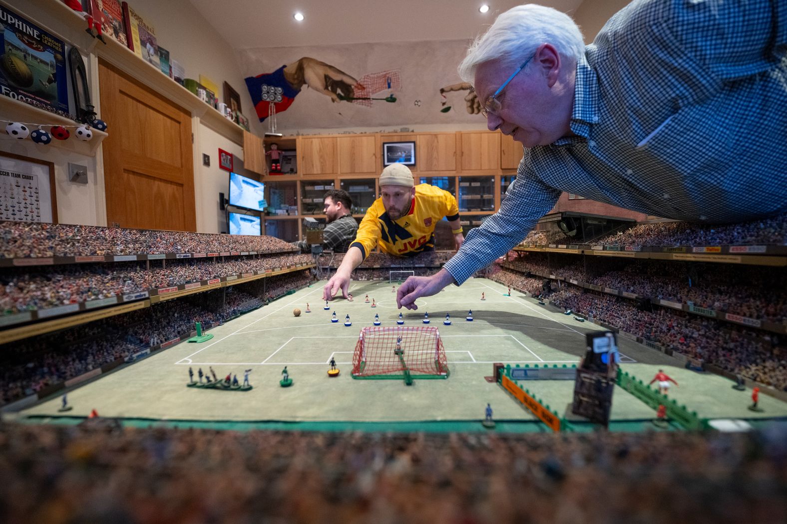 Fans of the tabletop football game Subbuteo play on handmade tables inside Stephen Morton’s house in Westcliff-on-Sea, England, on Sunday, December 29. Morton opens his house every year for Subbuteo enthusiasts to play on his elaborate tables.